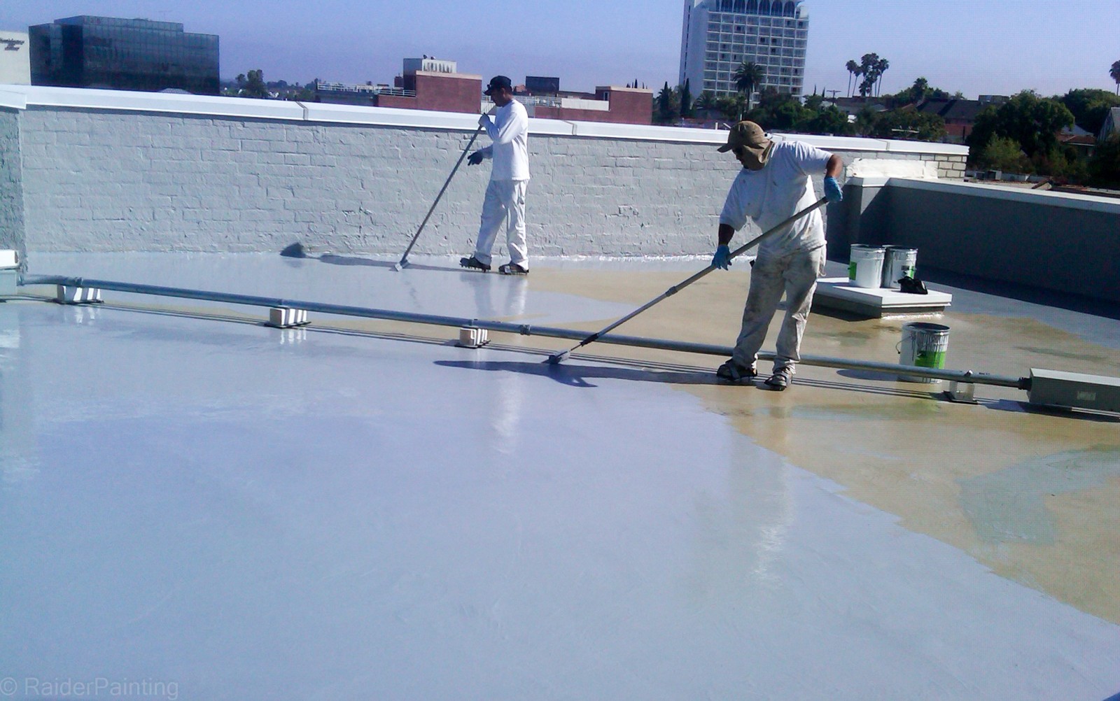 Flat roof maintenance in Brooklyn showing cleaning and inspection of drainage system on residential building